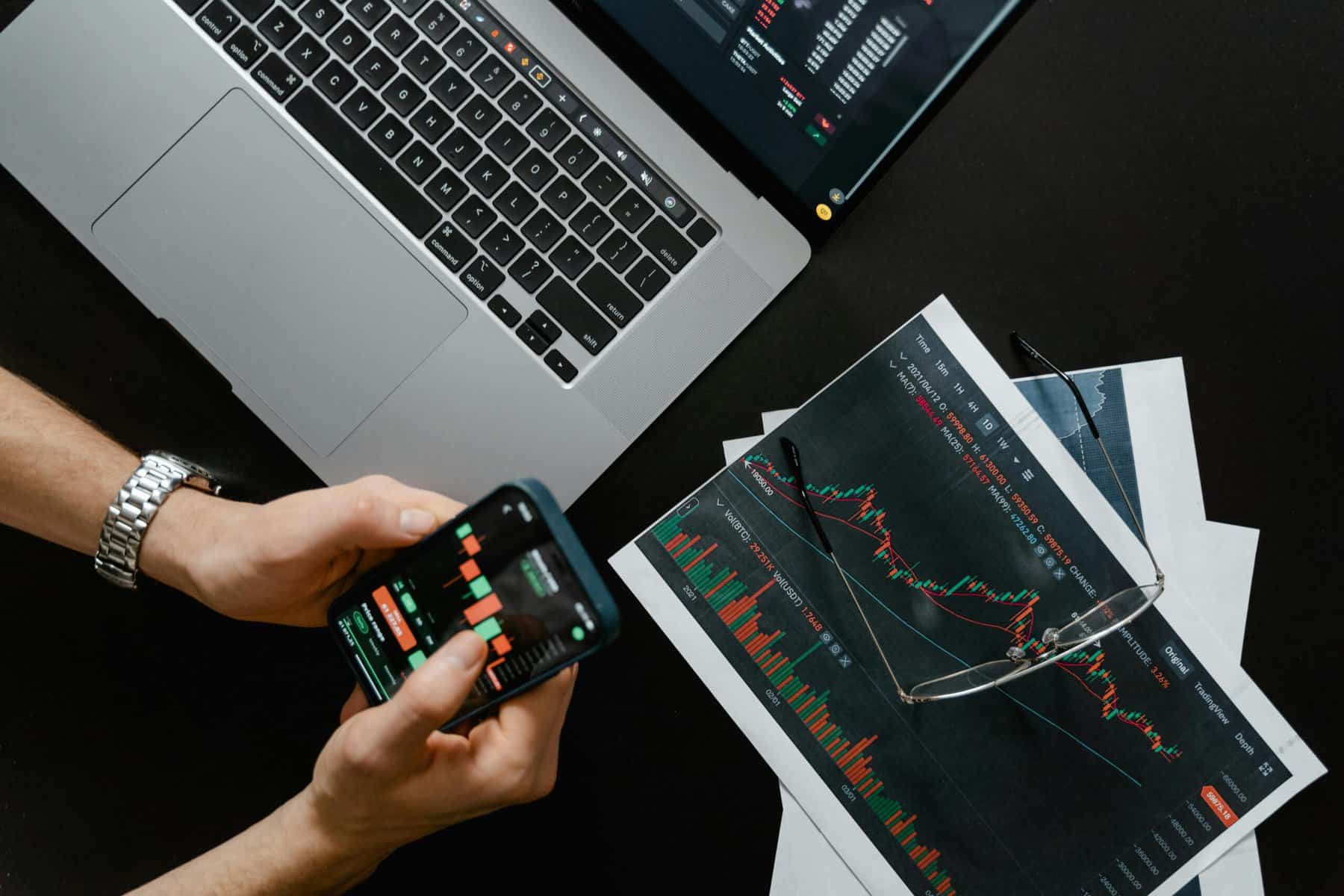 an image depicting someone holding a phone showing various asset charts to signify portfolio optimization